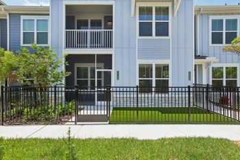 A blue building with a black fence and a green lawn in front.